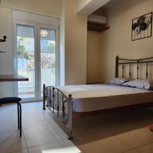 a bedroom with a bed and a large window at Elevate Blue Apartment in Rethymno Town