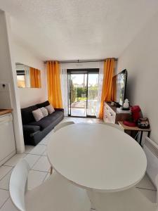 een woonkamer met een witte tafel en een bank bij Front de mer, 8min du Palais des Festivals in Cannes