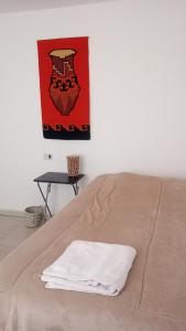 ein weißes Handtuch auf dem Bett in der Unterkunft Departamento a metros del Parque Central de Mendoza in La Cieneguita