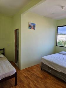 ウバジャラにあるCasa Mandacaruのベッド2台と窓のある寝室 +5枚の写真