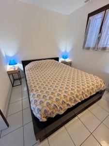 een bed in een kamer met twee lampjes op twee tafels bij Front de mer, 8min du Palais des Festivals in Cannes