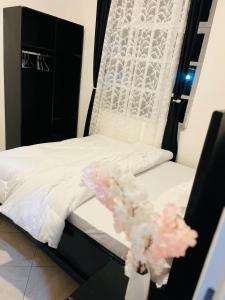 a bedroom with a bed with white sheets and pink flowers at Luna homes and stays in Moshi +23 photos