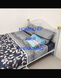 亚娄Homestay Amir Chemumaq的一张铺着黑白毯子和枕头的床 更多10张照片