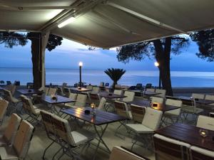 een restaurant met tafels en stoelen en uitzicht op de oceaan bij Boutique Camping Materada Beach in Poreč