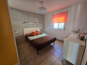 a small bedroom with a bed and a window at Casa Clavel in Ronda