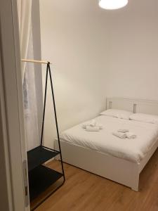 een slaapkamer met een wit bed en een zwarte standaard bij Harmony in Rome ll in Rome