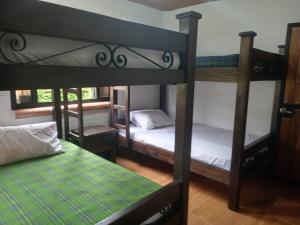 a room with three bunk beds and a green bed at Finca el Manantial in Papagalleros +20 photos