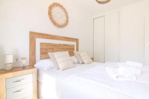 a white bedroom with a large white bed with white pillows at Riurau Home - 1ª línea Turmalina in Calpe
