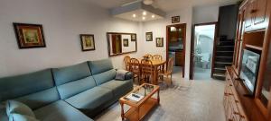 Una sala de estar con un sofá azul y una mesa. en Bungalow Catral 20 en Santa Pola, en Santa Pola