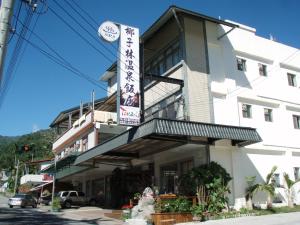 a building with a sign in front of it at Cocos Hot Spring Hotel in Ruisui