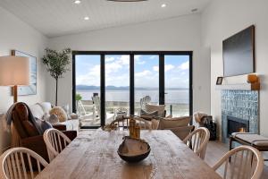 a living room with a wooden table and a fireplace at Saratoga Beachfront Villa in Oyster Bay