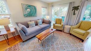 a living room with a couch and two chairs at Flip Flop Casual in Folly Beach