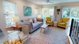 a living room with a couch and two chairs at Flip Flop Casual in Folly Beach