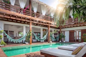 a villa with a swimming pool and hammocks at Villa Métisse in Jericoacoara