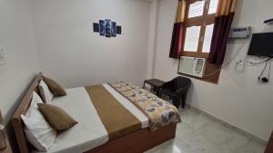una camera da letto con un letto, una finestra e una scrivania di Natraj Homes a Ayodhya