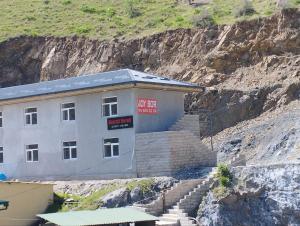 a building with stairs next to a mountain at Hazrati Dovud Guest House in Samarkand