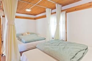 a bedroom with two beds and a window at Kouri Traditional House in Karpathos Town