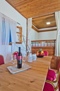 a bottle of wine sitting on a wooden table with wine glasses at Kouri Traditional House in Karpathos Town +38 photos