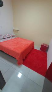 a bedroom with a red bed and a red rug at FLAT BRISA do MAR in Pitimbu +6 photos