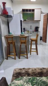 a kitchen with a table and two stools in it at FLAT BRISA do MAR in Pitimbu