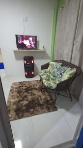 a living room with a couch and a tv at FLAT BRISA do MAR in Pitimbu +6 photos