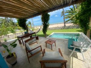 Un patio con piscina y sillas y una mesa. en Casa Vento, en Icaraí