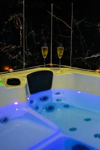 dwa kieliszki wina siedzące na wannie w obiekcie Maison spacieuse - Grand jacuzzi w Hawrze