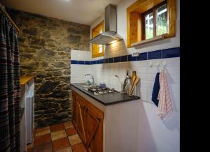 a kitchen with a sink and a stone wall at Casa Yamba in Montojo