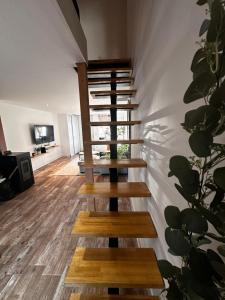 a wooden staircase in a living room with a wall at Charmante Maison in Abrest