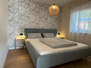 Un dormitorio con una cama y una lámpara de araña. en Auszeit am Schwielowsee - Moderne Ferienwohnung direkt am Schwielowsee, en Schwielowsee