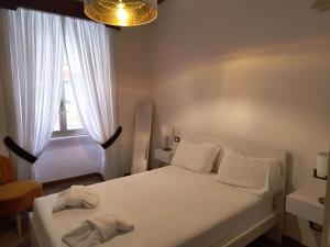 ein Schlafzimmer mit einem weißen Bett und einem Fenster in der Unterkunft The Apartment in Rom + 8 Fotos