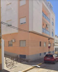 a building with a red car parked in front of it at Esperanza free parking by Staycare in Rota