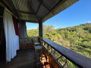a room with a balcony with a view of the forest at Cabañas Mi Bello Atardecer in San José del Fragua