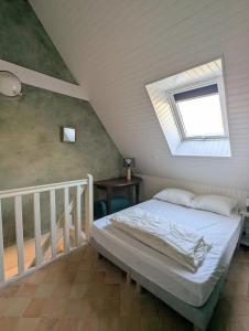 Saint-AlbanにあるCasa Bretonne- Grand terrain- 7mn de la plage-のベッドルーム1室(窓のある屋根裏部屋のベッド1台付)
