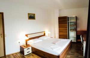 a bedroom with a large white bed and a closet at Apartments Angela in Goveđari