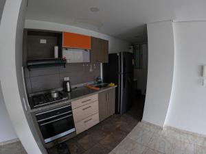a small kitchen with a stove and a refrigerator at Altos del Nogal in Moniquirá +2 photos