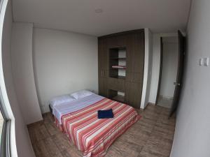 a bedroom with a bed with a book on it at Altos del Nogal in Moniquirá