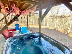 a jacuzzi tub in a porch with a yard at Hot Tub, Deck, Grill, Fire Pit, Game Room & WiFi in Great Cacapon