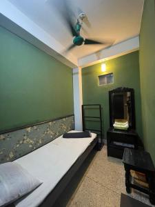 a room with a bed and a ceiling fan at Hotel Hoque Tower International in Chittagong