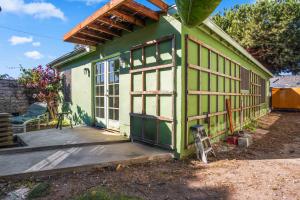 ein grünes und weißes Haus mit einer Veranda in der Unterkunft Steps to Venice Beach Vintage Venice Retreat in Los Angeles
