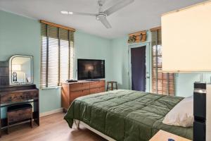 ein Schlafzimmer mit einem Bett und einem Flachbildfernseher in der Unterkunft Steps to Venice Beach Vintage Venice Retreat in Los Angeles