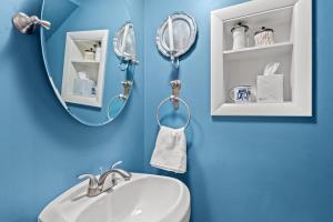 a blue bathroom with a sink and a mirror at The Cavalier in Alexandria +22 photos