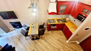 vista sul soffitto di una cucina con armadi rossi e tavolo di Rifugio Elite Terminillo a Terminillo