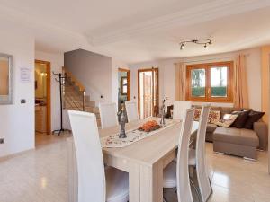 una sala da pranzo con tavolo in legno e sedie bianche di Casa Paraiso de Alcudia a Port d'Alcudia
