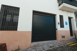 een zwarte garagedeur aan de zijkant van een gebouw bij Macarena Suites in Cáceres