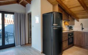 a black refrigerator in a kitchen with a balcony at Sitovolonas Superior Accommodation in Nafplio