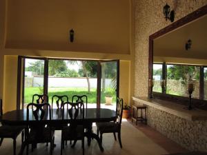 a dining room with a table and chairs and a large mirror at Casa de los Pianos in Uaymá