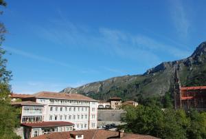 a large building with a view of the mountains at Arcea Gran Hotel Pelayo in Covadonga