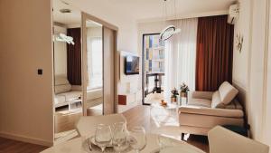 a living room with a couch and a table with wine glasses at White Pearl, Casa Al Mare in Rafailovici +27 photos