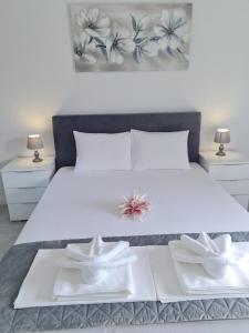 a bedroom with a white bed with two white towels at Manta in Lukovo Šugarje